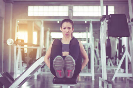 Beautiful asian woman doing situp or crunches in gym,Female exercise muscular her stomachの写真素材