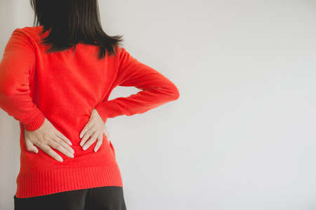 Woman with lower back pain,Female suffering from backache,Copy space and white blackgroundの写真素材