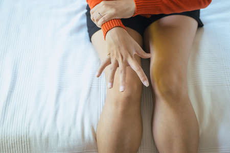Woman suffering with parkinson's disease symptoms in bedroom on white background and copy spaceの写真素材