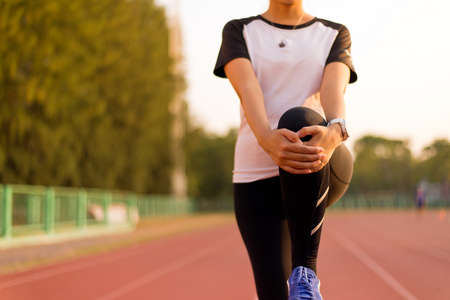 Sport runner woman stretching for warming up befor running doing exercises and workout trainingの写真素材
