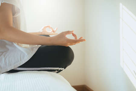 Close up of asian hands woman practices yoga and meditation in the lotus positionの写真素材