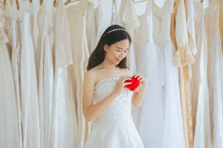 Happy young beautiful bride asian woman smiling and hand holding model red heartの写真素材