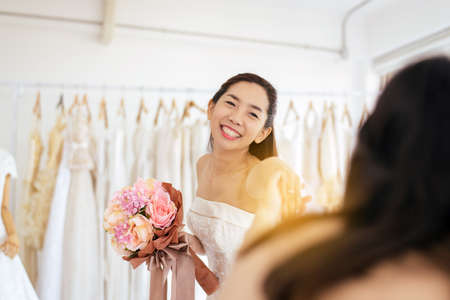 Happy bride asian woman smiling and cheerful with colorful flowers