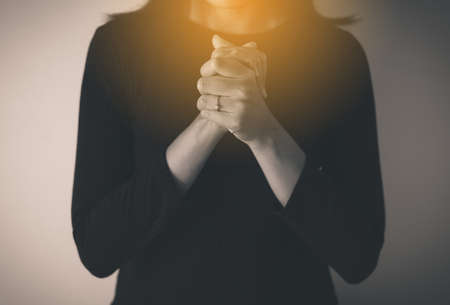 Female prayer hands clasped together,Woman with hand in praying position,Black and white tonedの写真素材