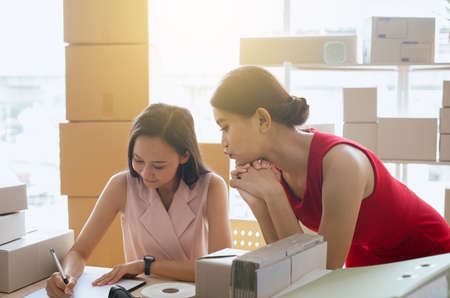 Small business couple beautiful asian woman owner work at home office together,SME online business and Start upentrepreneurの写真素材