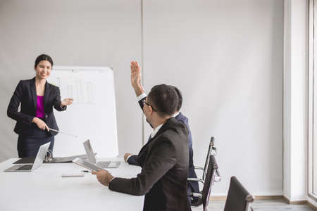 Asian business people in board room meeting,Team group discussing with hand raise up together in...