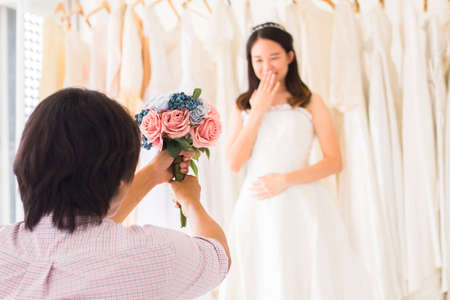 Groom give flower to surprise bride,asain woman positive emotion and face astonished,Romantic and...