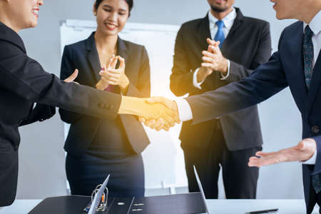 Business asian team people shaking hands after finishing up meeting in conference room