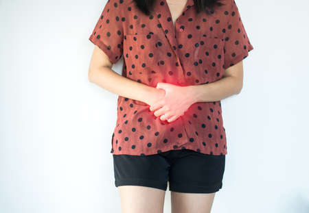 Woman having painful stomachache at home,Female suffering from abdominal pain,Period cramps,Hands...