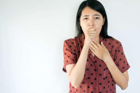 Beautiful asian woman coughing with sore throat,Female suffering with cough a lot on white background and copy space for textの写真素材