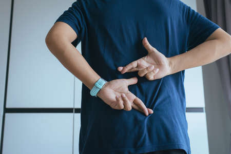 Lie of man with hand crossing fingers behind back telling liar and cheating,April Fools' Day conceptの写真素材