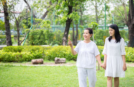 Portrait of a elderly asian woman with young women walking outdoor together in the morning,Positive thinkingの写真素材
