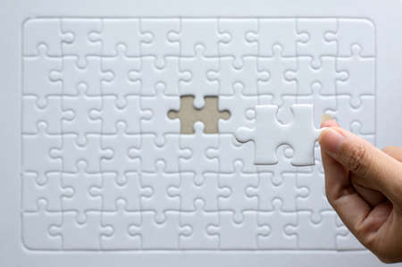 Hands women with jigsaw puzzle white color,Puzzle pieces grid,Success mosaic solution templateの写真素材