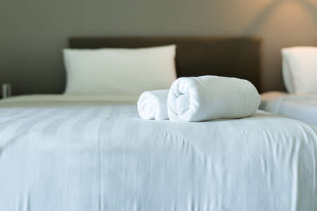 White hotel towel on bed,Stack of fluffy bath towels,Close up,Copy space for textの写真素材