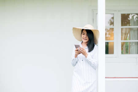 Portrait of beautiful asian female holding cell phone and smiling at home,Positive thinking,Good attitudeの写真素材