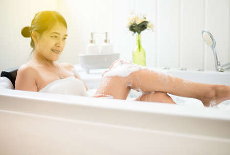 Beautiful asian woman relaxing in bubble bathtub,Female lying body in waterの写真素材