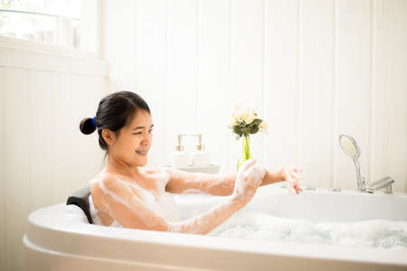 Beautiful asian woman relaxing in bubble bathtub,Female lying body in waterの写真素材