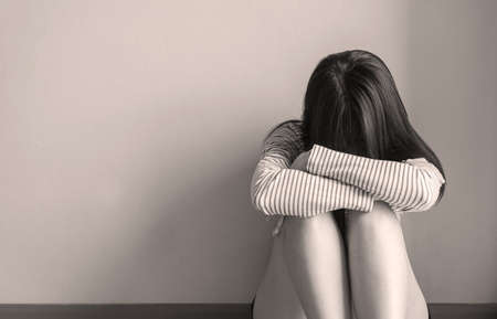 Asian woman sits and hugs knees up to the chest depression of lonely have a headache at home,Mental disorder health care,World suicide prevention day concept,Black and white tonedの写真素材