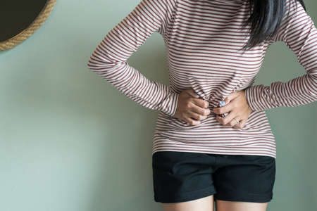 Asian female having painful stomachache,Women suffering from abdominal pain,Period cramps or...
