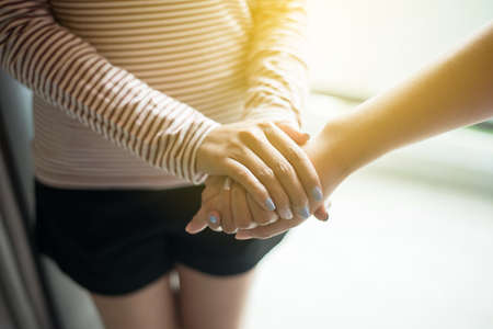 Picture of couple women friends holding hands and caring supporting comforting together,Encouragement conceptの写真素材