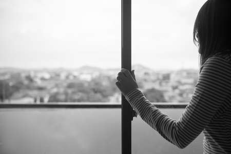 Contraception and unexpected pregnancy concept,Asian women sitting on bedroom at home,Female feeling headache and confused problem in personal life,Black and white tonedの写真素材