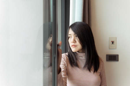 Contraception and unexpected pregnancy concept,Asian women sitting on bedroom at home,Female feeling headache and confused problem in personal lifeの写真素材