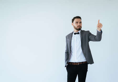 Handsome men with bearded in formal tuxedo and suit showing hand pointing something on white background,Copy space for text and die cutの写真素材