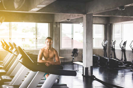 Fit man standing and smiling relax after the training session in gym,Concept healthy and...