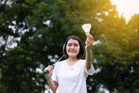 Beautiful asian woman playing badminton in nature,Happy and smilingの写真素材