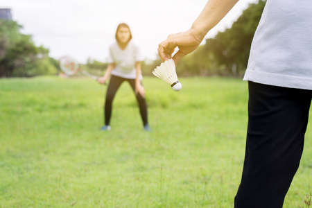 Close up of hands woman holding badminton racket and shuttlecock in public parkの写真素材