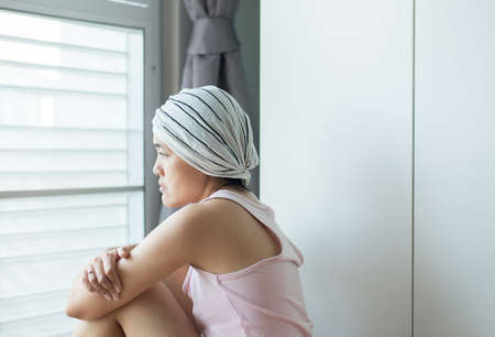 Asian woman with disease cancer is looking something and sitting at homeの写真素材