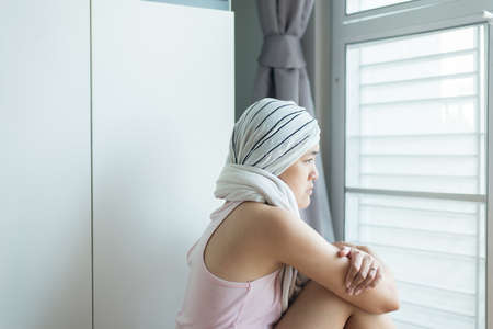 Young asian women with disease cancer is looking something and sitting at houseの写真素材