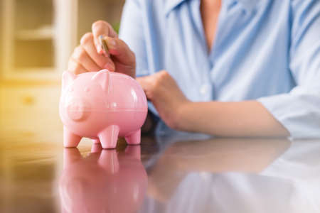 Senior hands putting coin to piggy bank for retirement, Saving money concept, Saving money concept