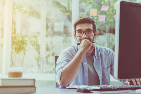 Portrait of handsome man with beard  while working online at home, Happy and smilingの写真素材
