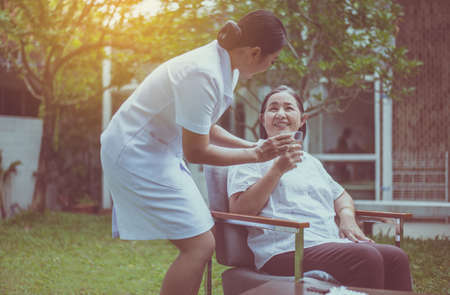 Senior asian woman hands holding a glass of water with pills, Nursing home care concept