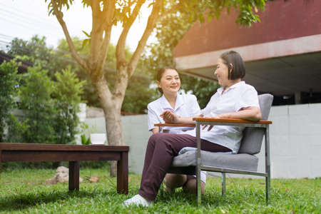 Senior patient woman hands holding with caregiver, Nursing home care conceptの写真素材
