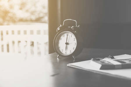 Close up of modern black color alarm clock at 6 o'clock on table in the moningの写真素材