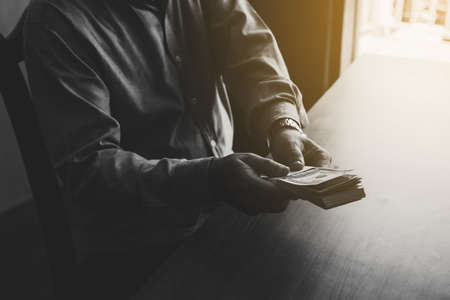 Man hand holding US dollar bills give to someone,Corruption concept,Black and white tonedの写真素材