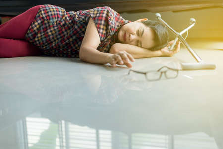 Senior asian female suffering with faint lying on floor after falling down at homeの写真素材
