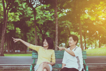 Elderly asian older mother happy with daughter take care and support at outdoor,Hands pointing somethingの写真素材