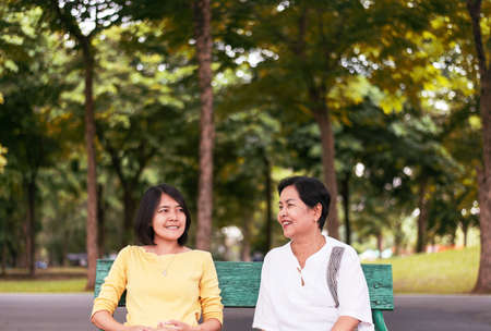 Portrait of middle aged asian female with daughter talking together at outdoor,Happy and smiling,Positive thinking,Take care and support conceptの写真素材