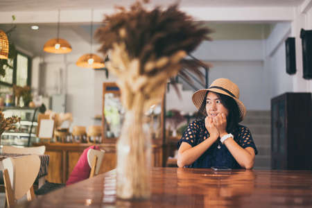 Beautiful Asian woman sitting in cafe,Happy and smiling,Positive thinkingの写真素材
