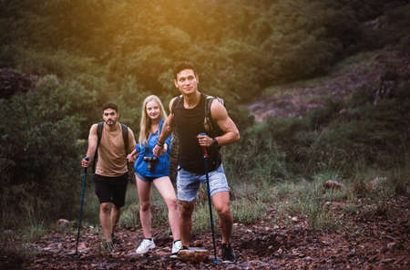 Group of backpackers best friends getting help together,Helping hand,Overcoming obstacle conceptの写真素材