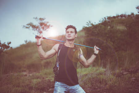 Handsome male holding trekking pole and looking something at nature,Happy and smiling,Travel at outdoorの写真素材