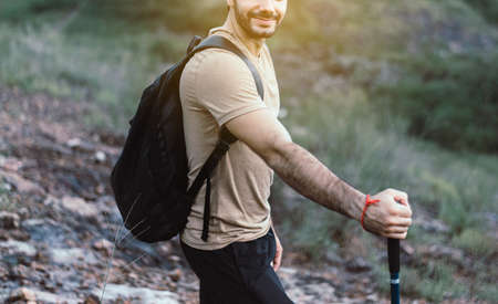 Portrait of young handsome man holding trekking pole at nature,Happy and smiling,Travel at outdoor,Close upの写真素材