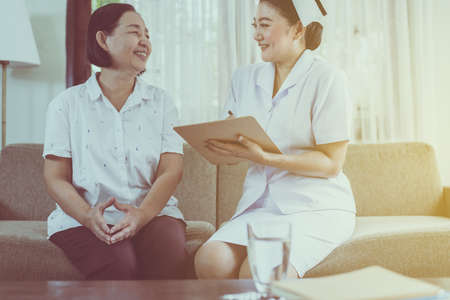 Mental health care concept. Professional psychologist writing note and consultation to senior asian...