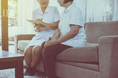 Mental health care concept. Professional psychologist writing note and consultation to senior asian woman patientの写真素材