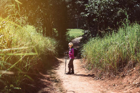 Backpacking asian woman walking with trekking pole in the morning at outdoor,Camping hiking conceptの写真素材