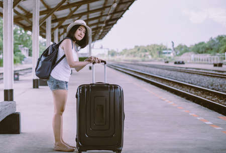 Hipster beautiful asian woman waiting train at train station,Happy and smiling,Travel and vacation conceptの写真素材