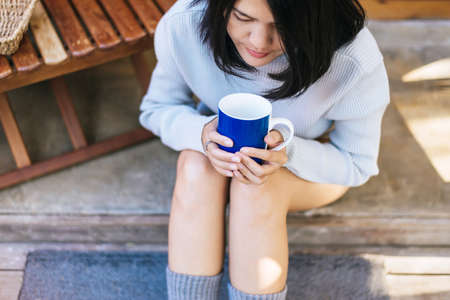 Beautiful asian woman holding and drinking a cup of coffee in the morning,Enjoys of resting time,Close upの写真素材